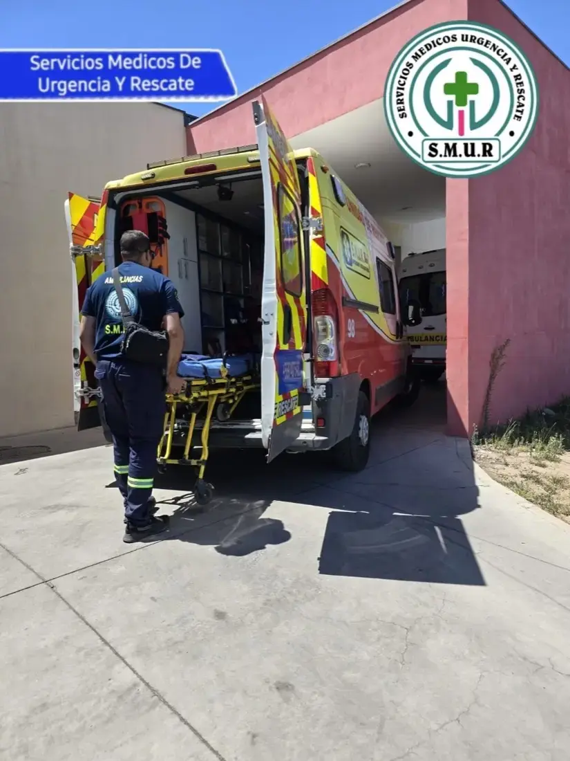 Integrante de S.M.U.R. con la camilla junto a una ambulancia
